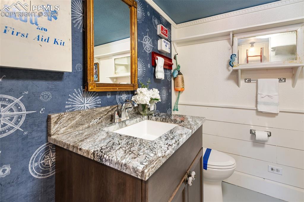 123 7th Street Victor, CO 80860 - Photo 32 of 44 a bathroom with a granite countertop sink and a toilet