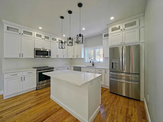 a view of a hallway with wooden floor and closet