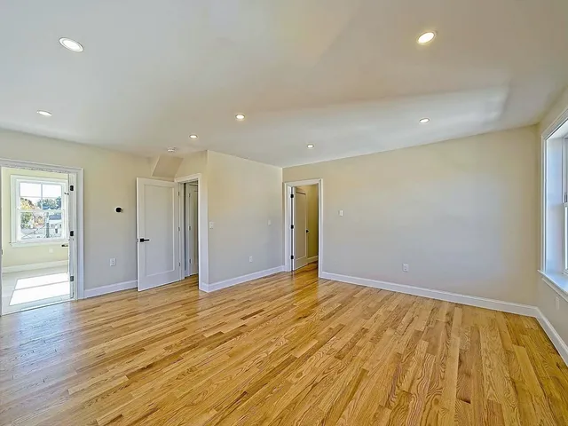 a view of an empty room with wooden floor