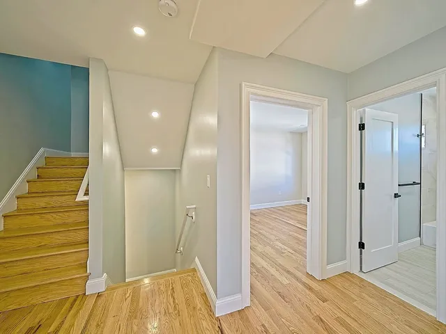 a view of a hallway with wooden floor and closet