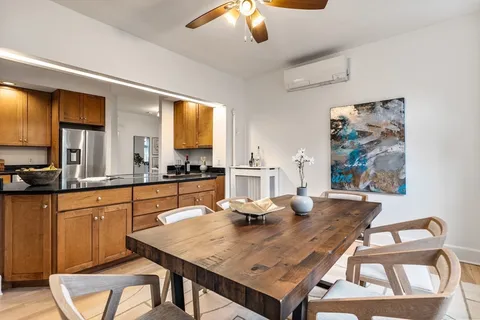 a kitchen with stainless steel appliances wooden floor dining table and chairs