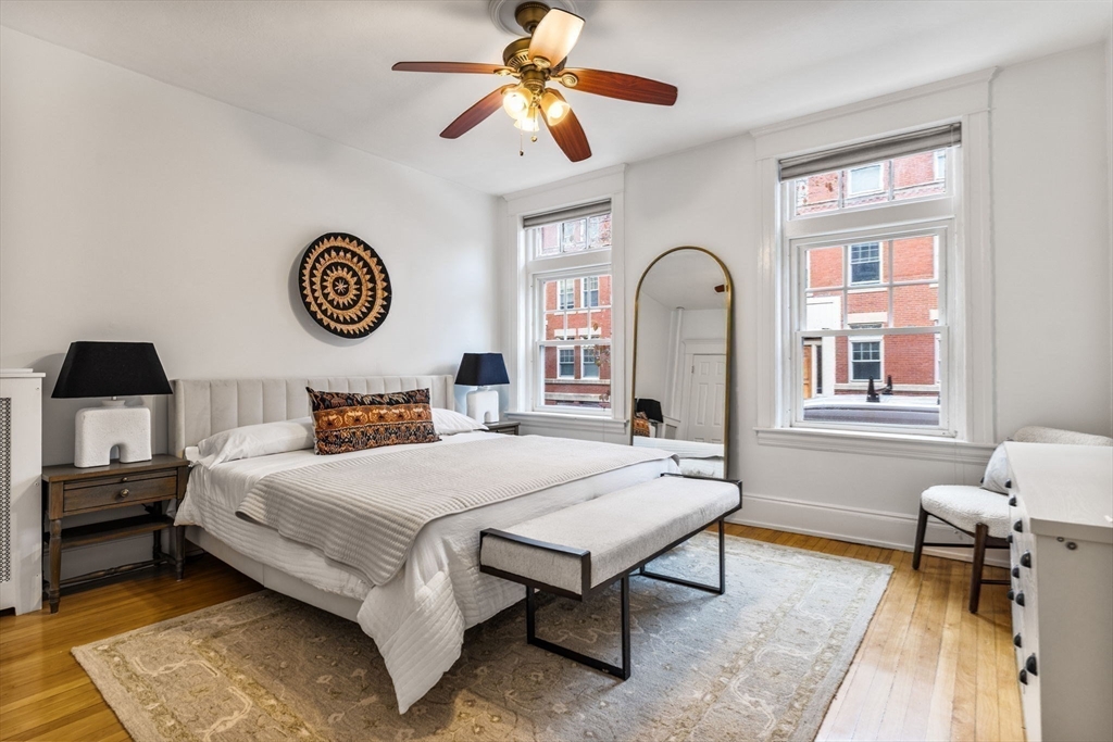 151 Longwood Avenue, Unit 1 Brookline, MA 02446 - Photo 13 of 34 a bedroom with a bed and a chandelier