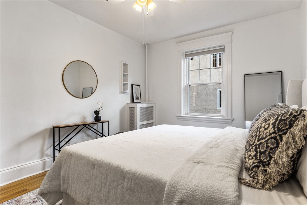 151 Longwood Avenue, Unit 1 Brookline, MA 02446 - Photo 16 of 34 a bedroom with a bed and a chandelier