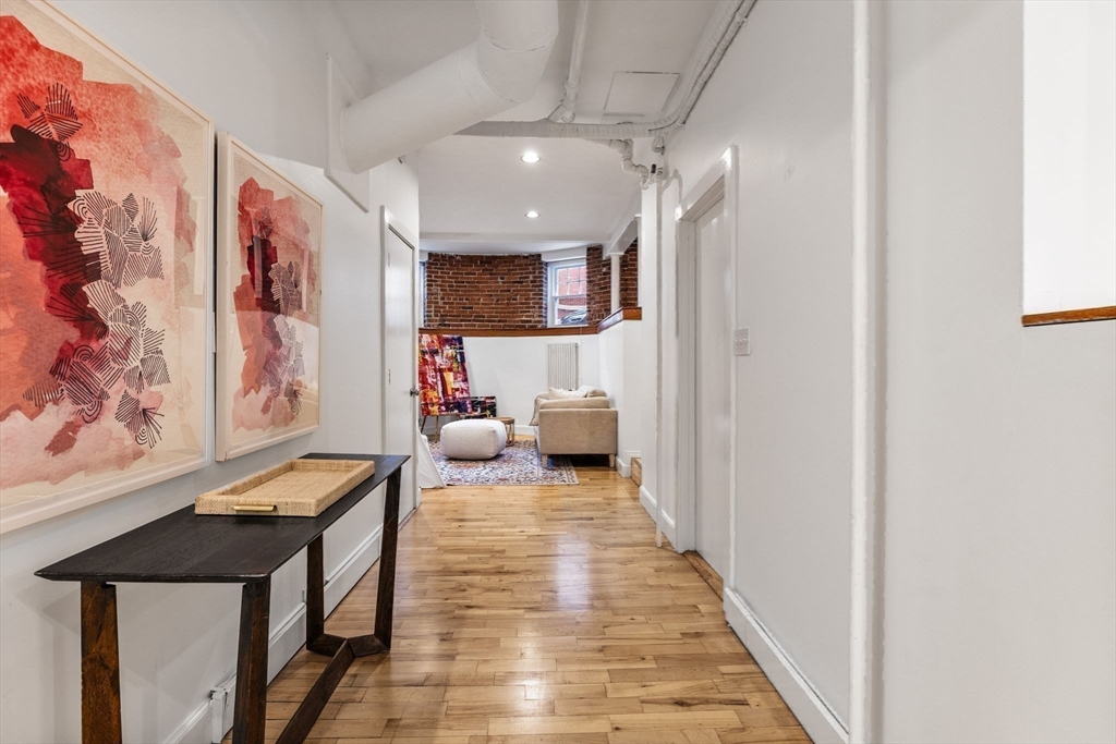 151 Longwood Avenue, Unit 1 Brookline, MA 02446 - Photo 20 of 34 a view of a hallway to a livingroom with furniture and wooden floor