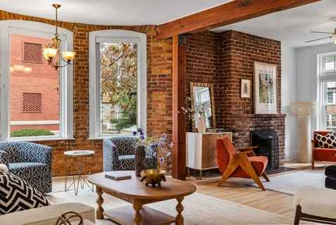 a living room with furniture a window and a fireplace