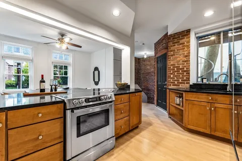a kitchen with stainless steel appliances granite countertop a stove a sink and a refrigerator