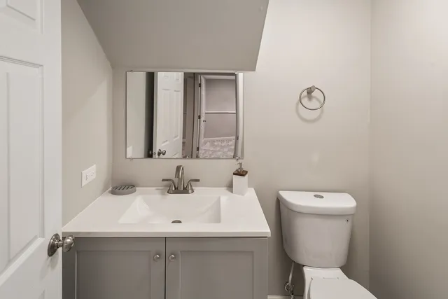 a bathroom with a toilet sink and mirror