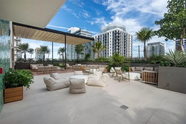 a view of a patio with couches and table and chairs and potted plants