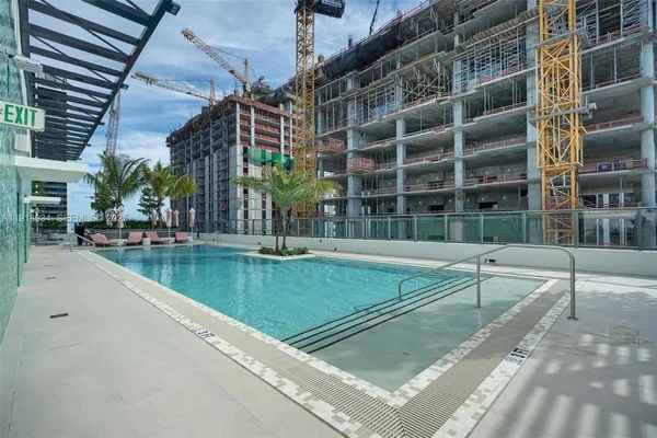 a view of a swimming pool with a bench in front of house