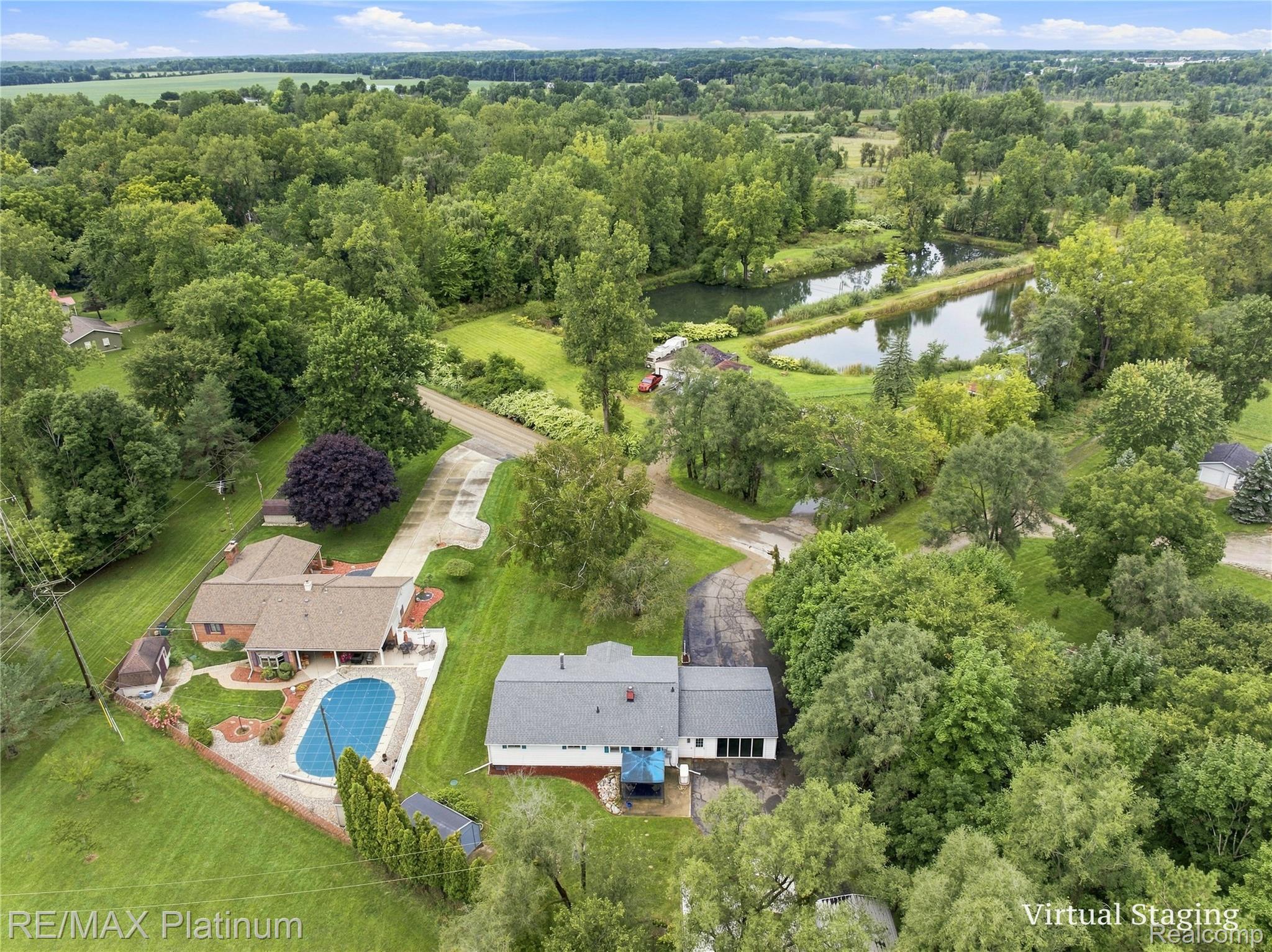 1609 West Dewey Road Owosso, MI 48867 - Photo 6 of 32 Expansive property featuring two distinct residences, a large in-ground swimming pool, two ponds, and mature landscaping