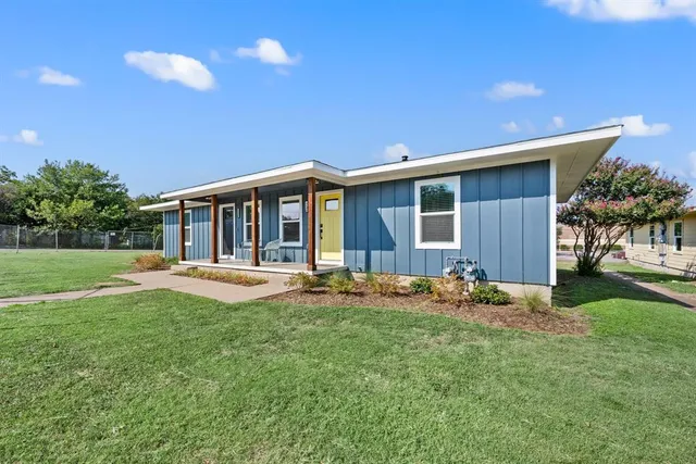 a front view of a house with yard and green space
