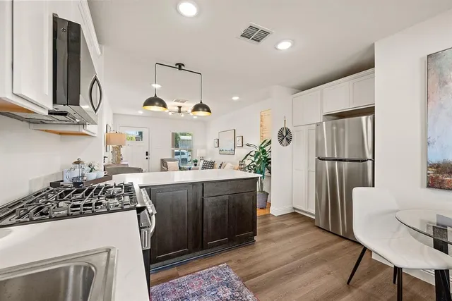 a kitchen with a refrigerator and a stove top oven
