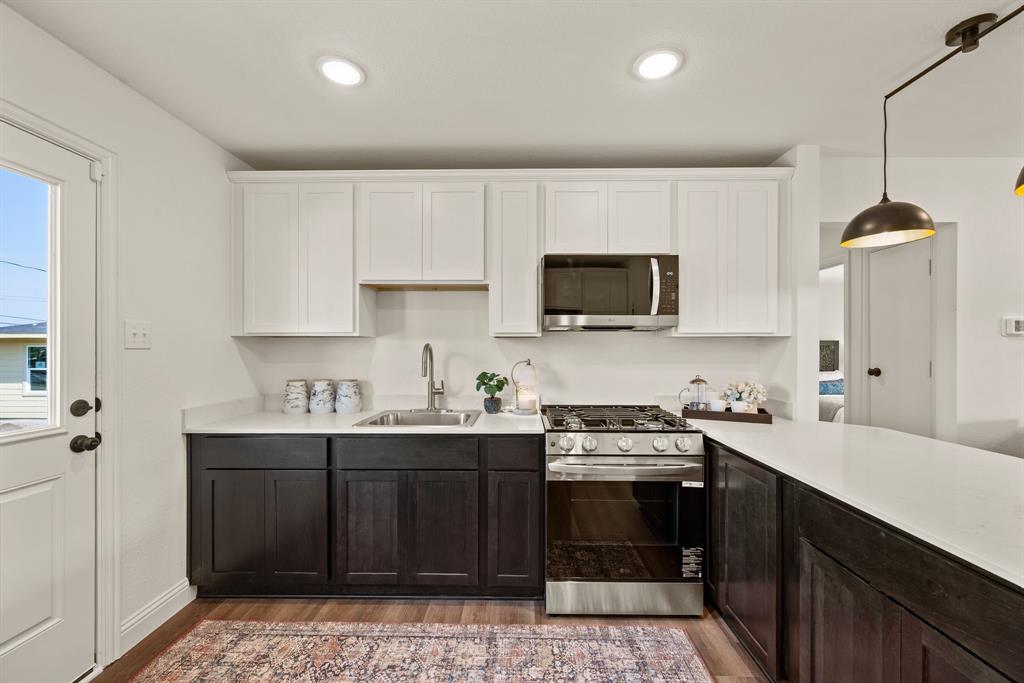 4092 Merida Avenue Fort Worth, TX 76110 - Photo 8 of 19 Sleek stainless steel and black appliances include Gas Range and Microwave; Under sink is prewired for a disposal