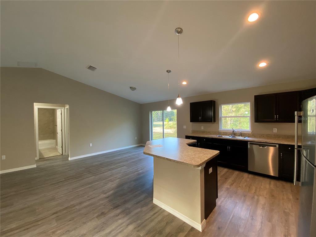5366 Southwest 197th Terrace Dunnellon, FL 34431 - Photo 9 of 29 a kitchen with stainless steel appliances kitchen island granite countertop a stove a sink and a microwave