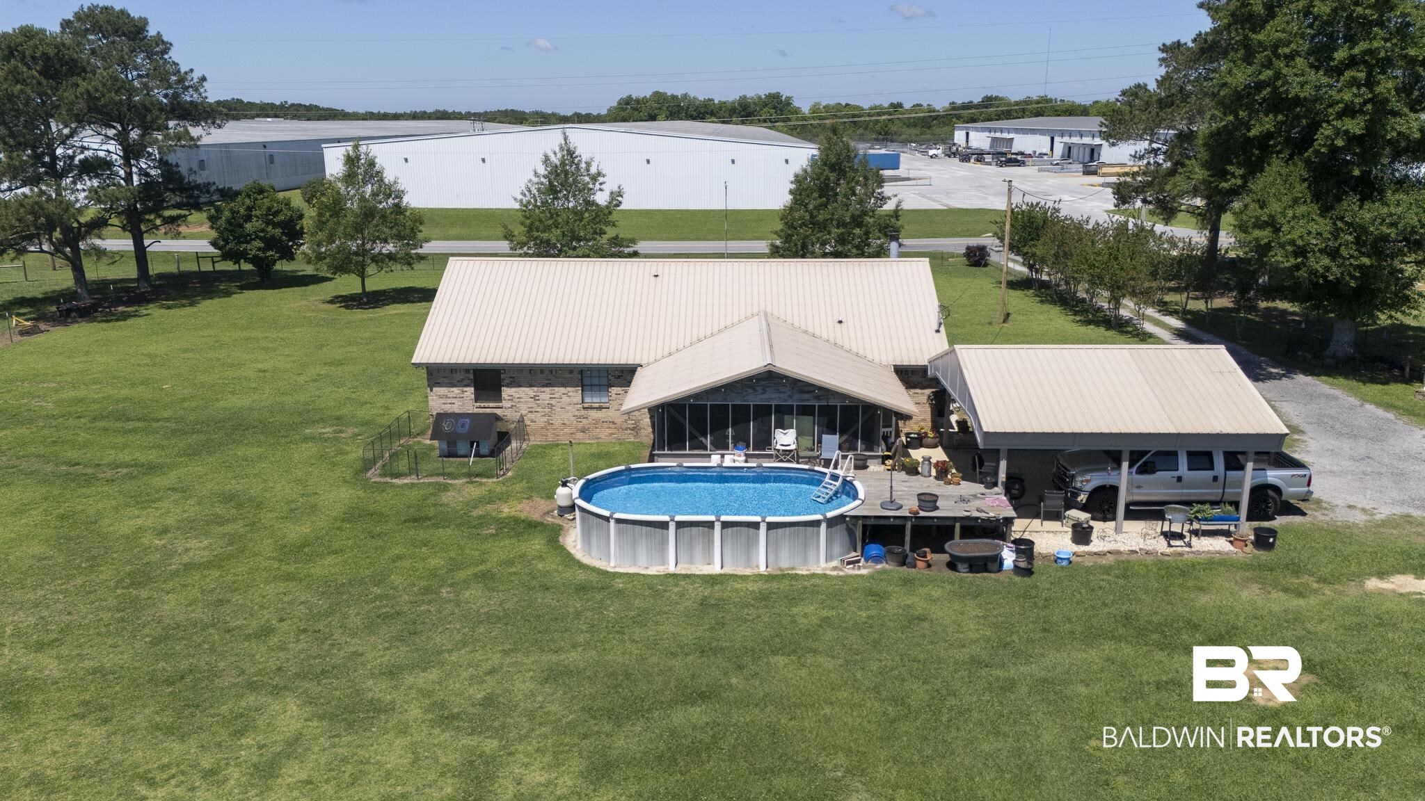 30580 County Road 49 Loxley, AL 36551 - Photo 24 of 32 Expansive green lawn surrounds a brick and siding residence with a light-colored metal roof