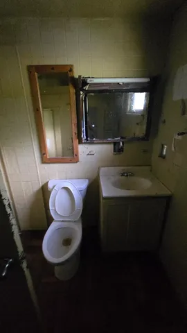 a bathroom with a toilet sink and mirror