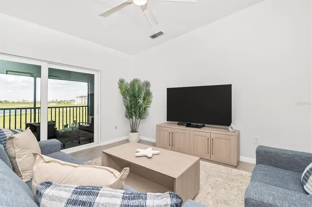 a living room with furniture and floor to ceiling windows