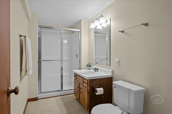 a bathroom with a sink a toilet a mirror and shower