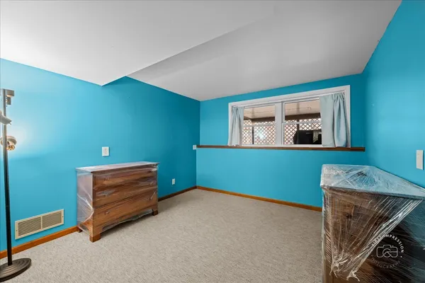 a room with painting on the wall and a window