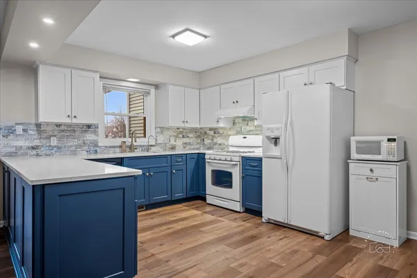 a kitchen with a sink a stove a refrigerator and cabinets