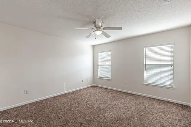 a view of a livingroom with a ceiling fan & entryway