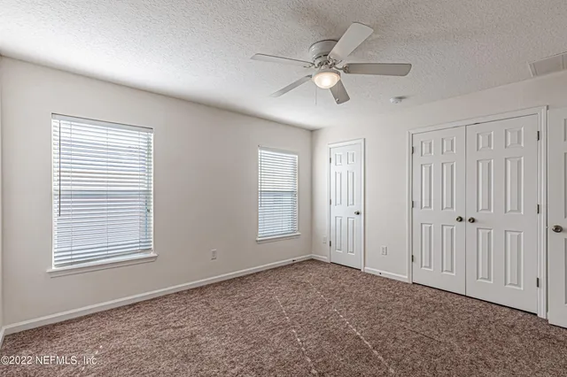 a bathroom with a granite countertop double vanity sink and a bathtub