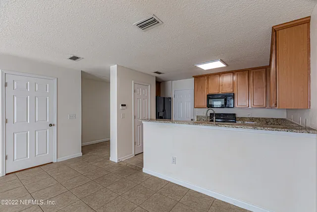a view of kitchen with stainless steel appliances a refrigerator and a stove top oven