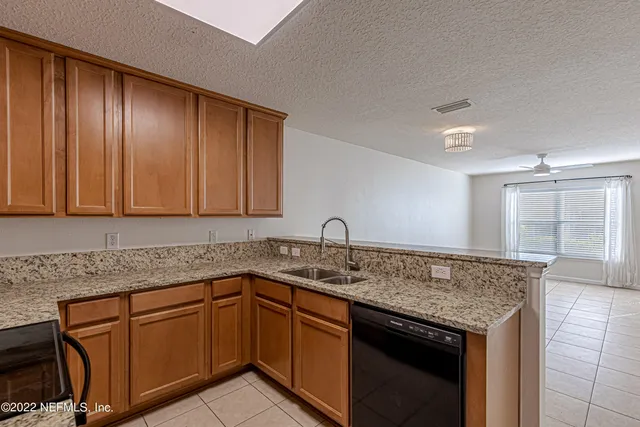 a kitchen with granite countertop cabinets sink and stove