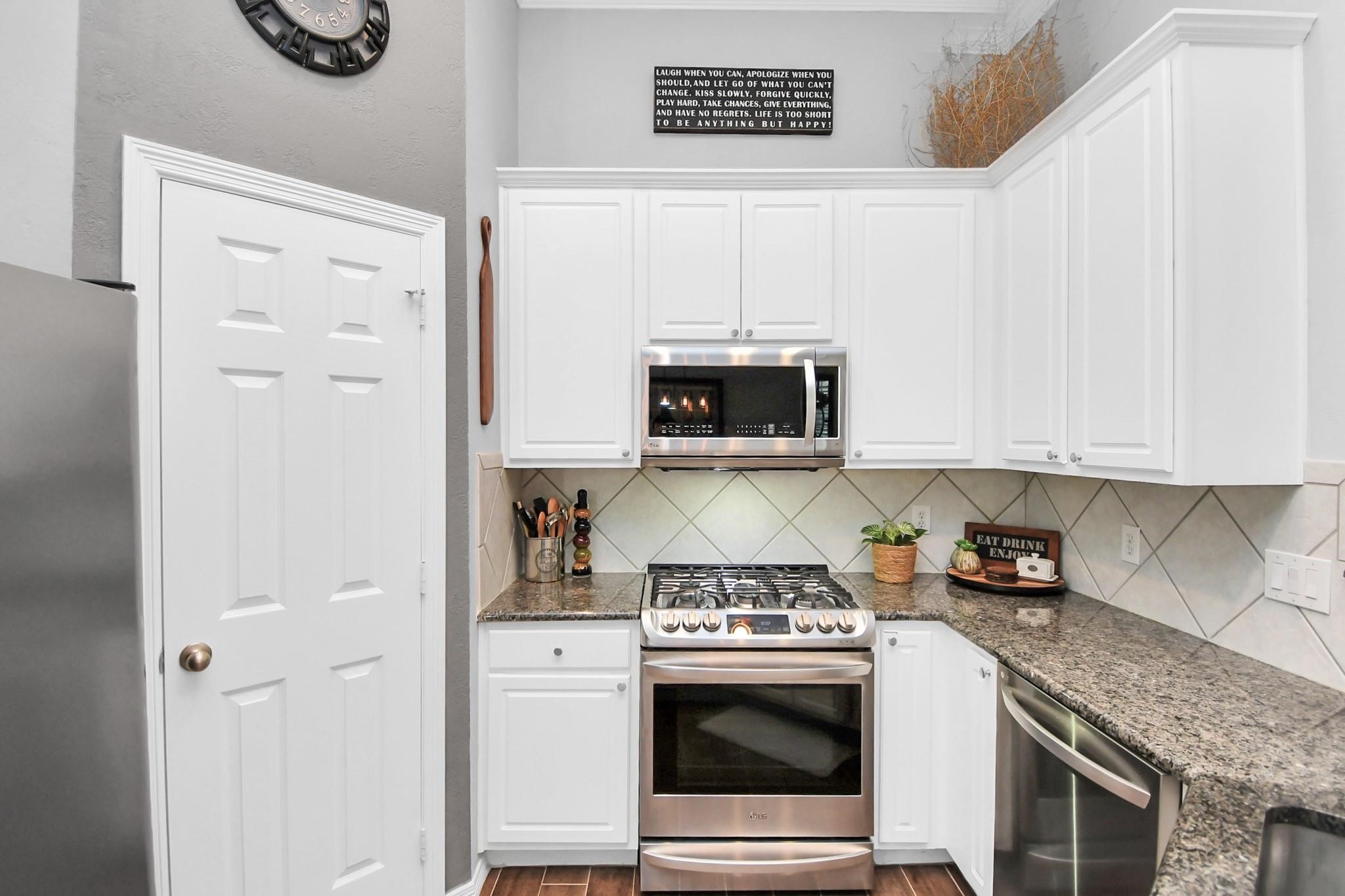 8624 Sunset Loch Drive Spring, TX 77379 - Photo 15 of 44 a kitchen with stainless steel appliances granite countertop white cabinets and a stove