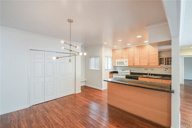 a kitchen with stainless steel appliances granite countertop a sink a stove and a refrigerator