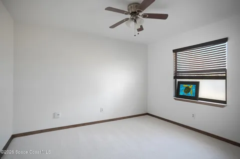 an empty room with a window and a fan