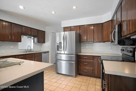 a kitchen with stainless steel appliances wooden cabinets a sink and a center island
