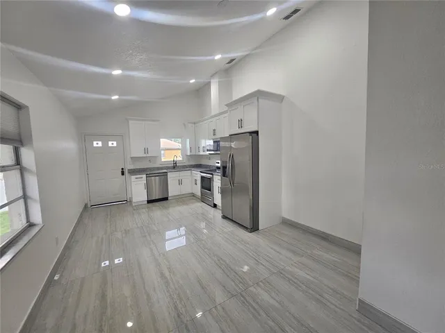 a view of kitchen with wooden floor and electronic appliances