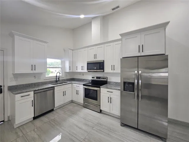 a kitchen with a refrigerator and a sink