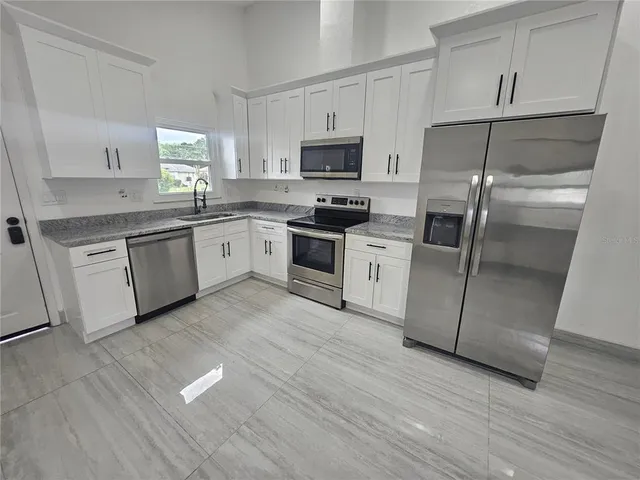 a kitchen with granite countertop stainless steel appliances and wooden cabinets