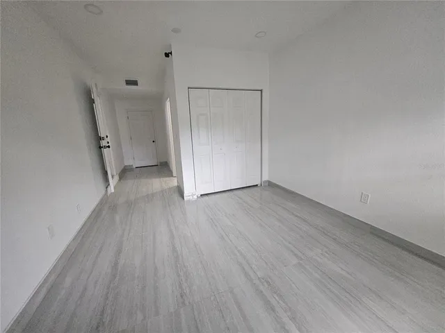 a view of a room with wooden floor and white doors