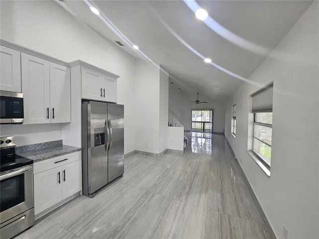 a kitchen with stainless steel appliances a refrigerator stove and microwave