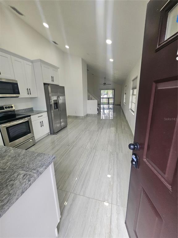 5802 Mohr Loop, Unit 5802 5804 5806 5808 Tampa, FL 33615 - Photo 8 of 40 a kitchen with stainless steel appliances granite countertop a refrigerator a sink a stove and a microwave
