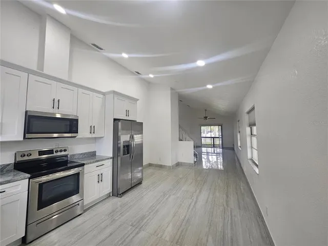 a kitchen with a refrigerator and a stove top oven