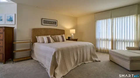 a bed sitting in a spacious bedroom next to a window