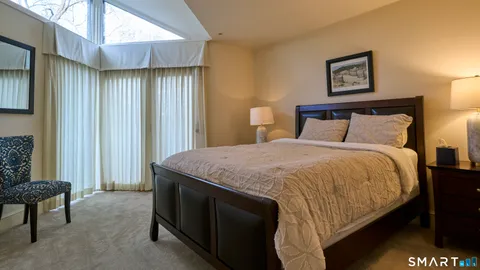 a spacious bedroom with a bed and a lamp