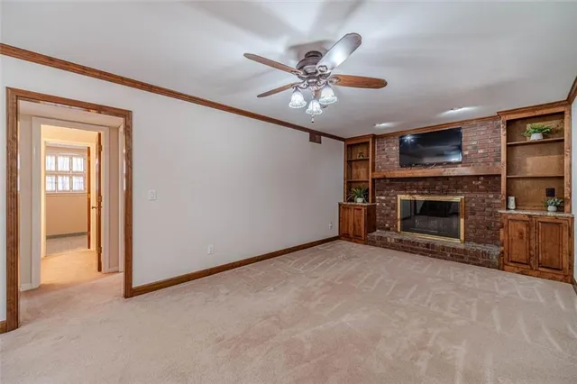 an empty room with windows and ceiling fan