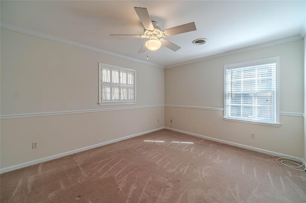 565 James Street Southwest Lilburn, GA 30047 - Photo 21 of 67 an empty room with windows and ceiling fan