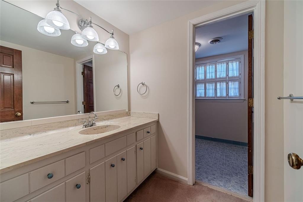 565 James Street Southwest Lilburn, GA 30047 - Photo 22 of 67 a spacious bathroom with a granite countertop sink a light fixture and a mirror