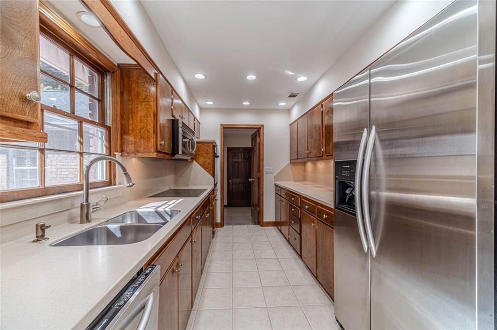 565 James Street Southwest Lilburn, GA 30047 - Photo 23 of 67 a kitchen with stainless steel appliances granite countertop a sink and a refrigerator