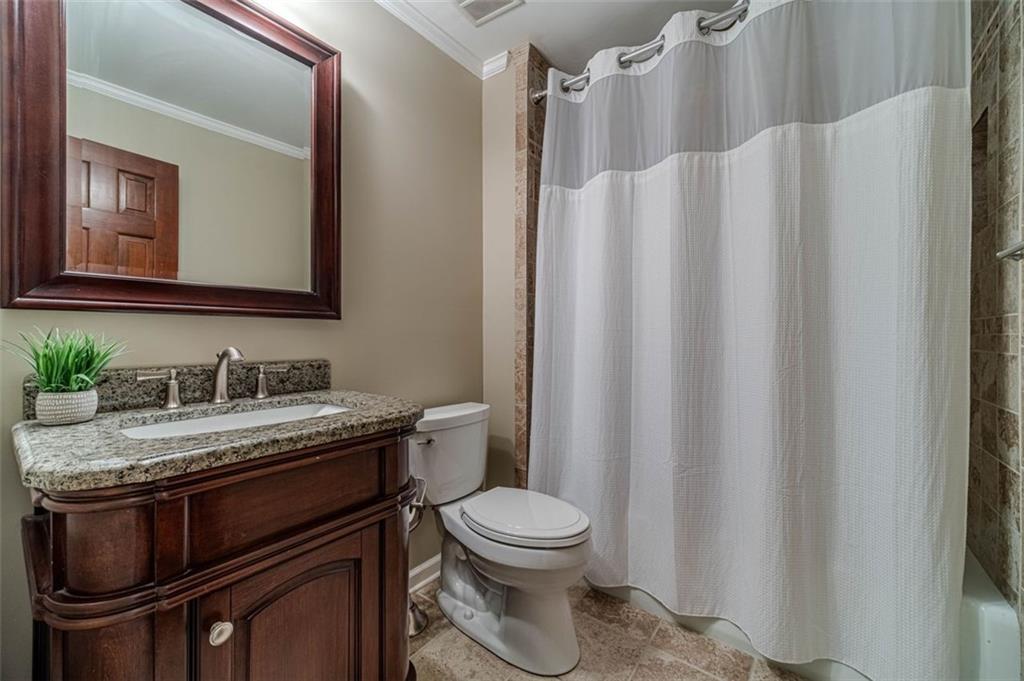 565 James Street Southwest Lilburn, GA 30047 - Photo 32 of 67 a bathroom with a granite countertop sink toilet and mirror