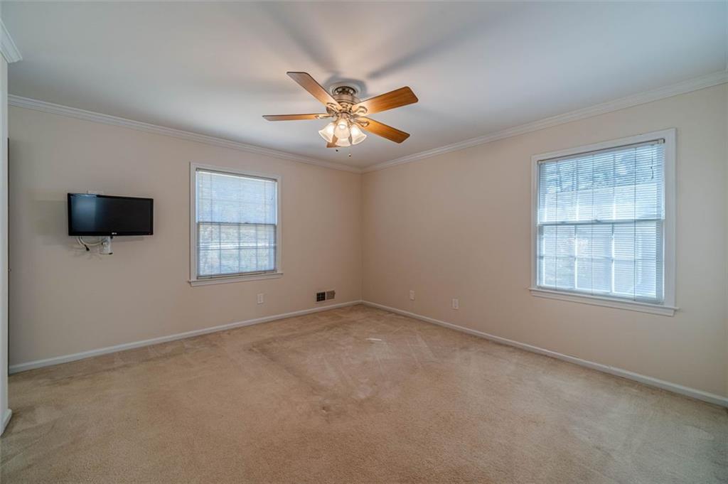 565 James Street Southwest Lilburn, GA 30047 - Photo 35 of 67 an empty room with windows and a ceiling fan