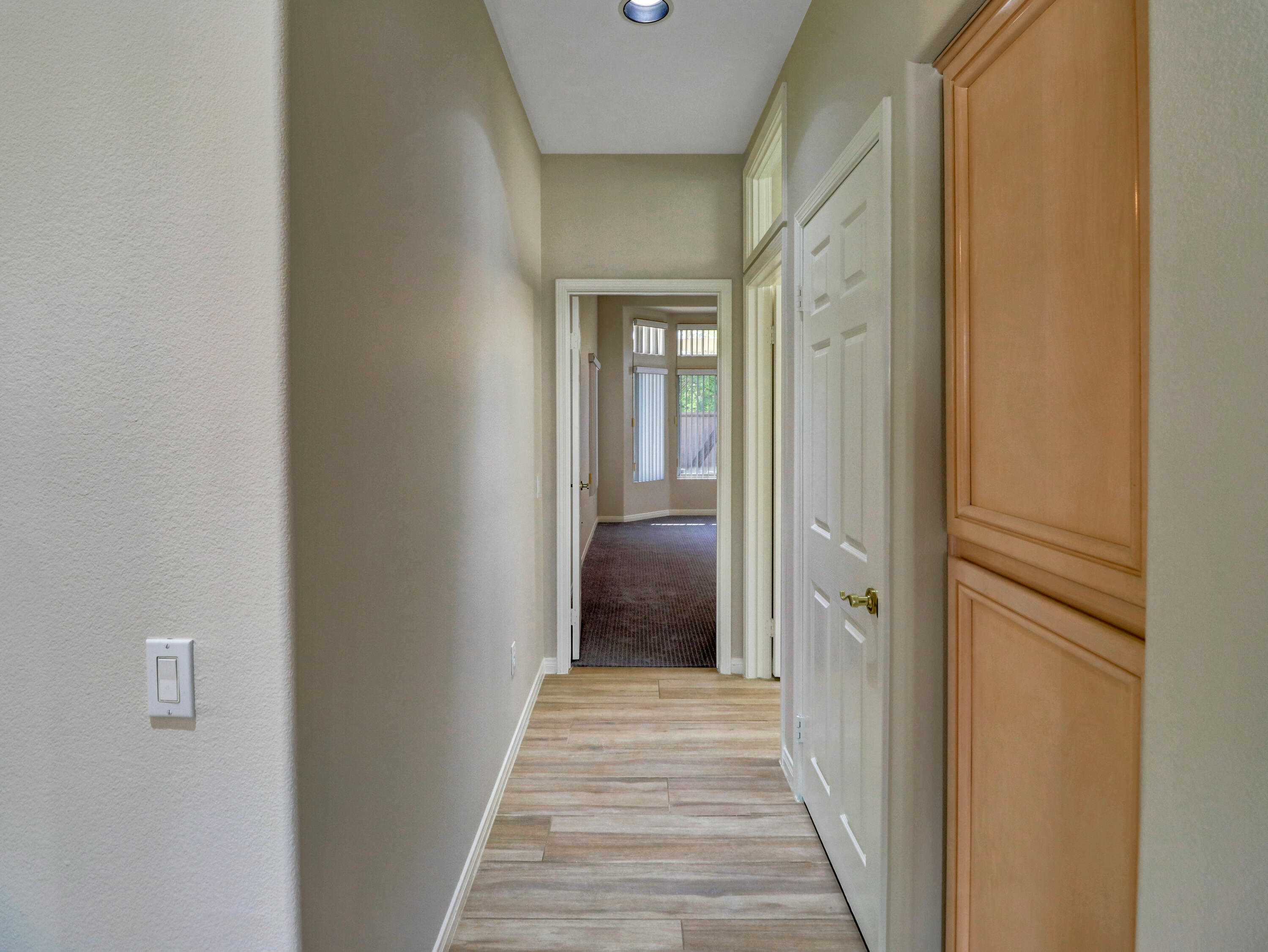 38574 Clear Sky Way Palm Desert, CA 92211 - Photo 15 of 69 a view of a hallway with wooden floor and a bathroom