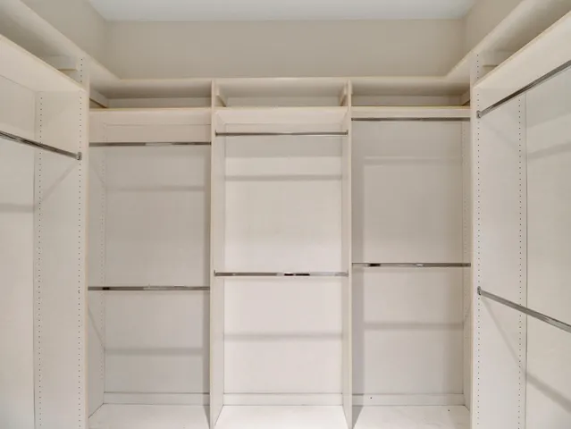 a view of a hallway with wooden floor and a bathroom