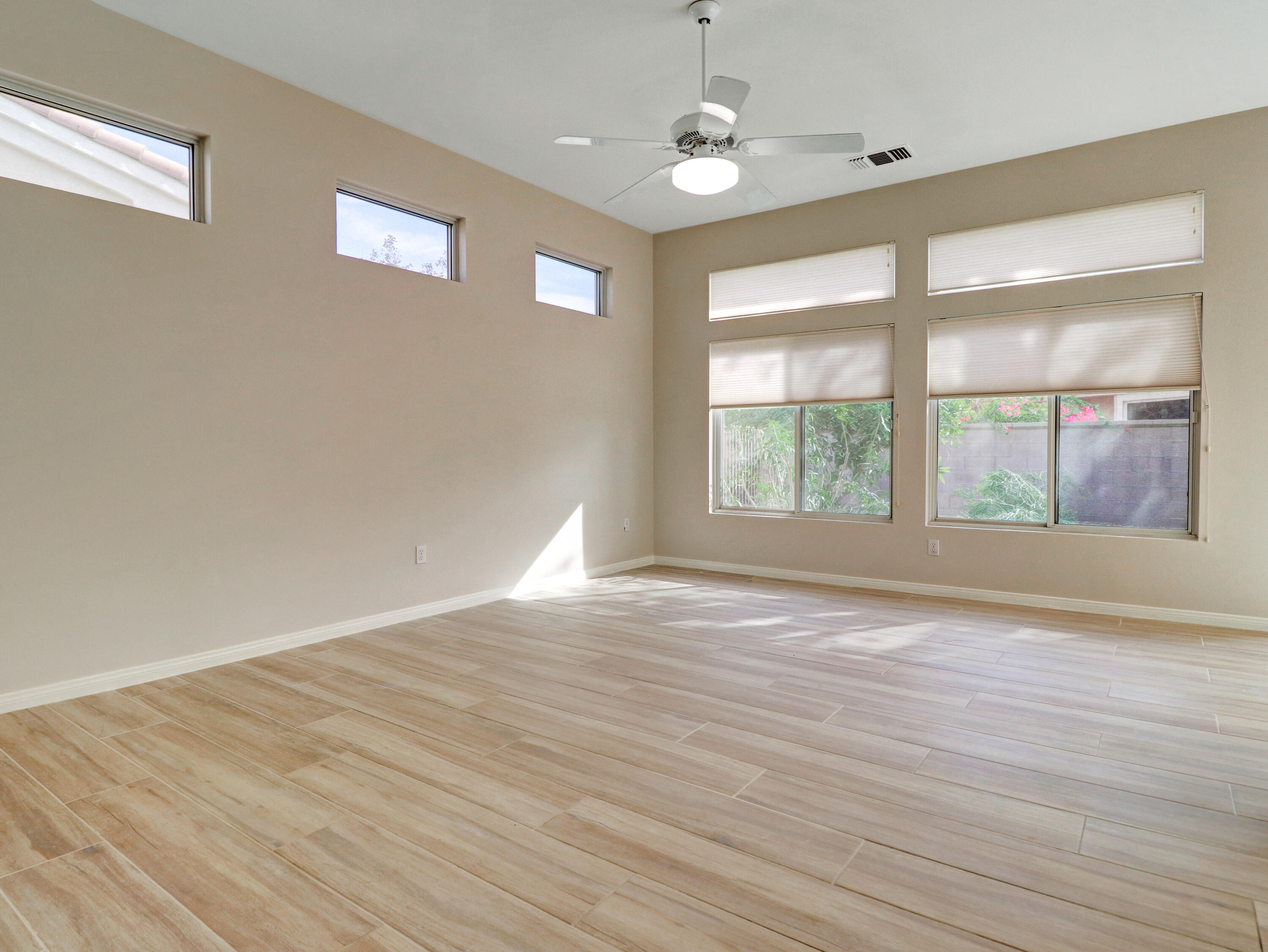 38574 Clear Sky Way Palm Desert, CA 92211 - Photo 33 of 69 an empty room with wooden floor and windows